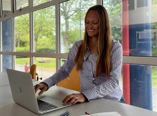 Debora Madile, fundadora da A Arquiteta da tua Marca, enquanto trabalha no seu computador.